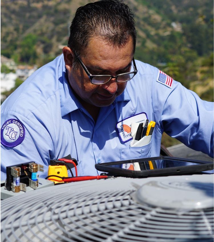 Image of a technician on a Beverly Hills house performing an AC maintenance service